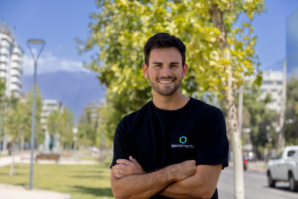 Ignacio Parada sonriendo con los brazos cruzados, vistiendo una camiseta negra con el logo de Bioelements en un entorno natural